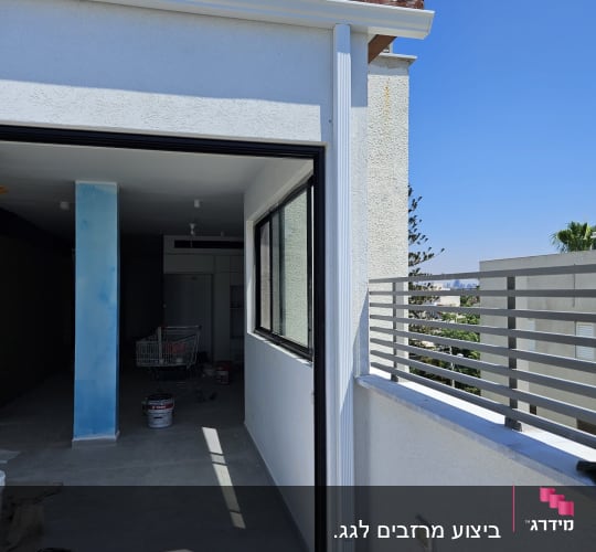גג רעפים חום עם מרזב לבן על קיר חיצוני